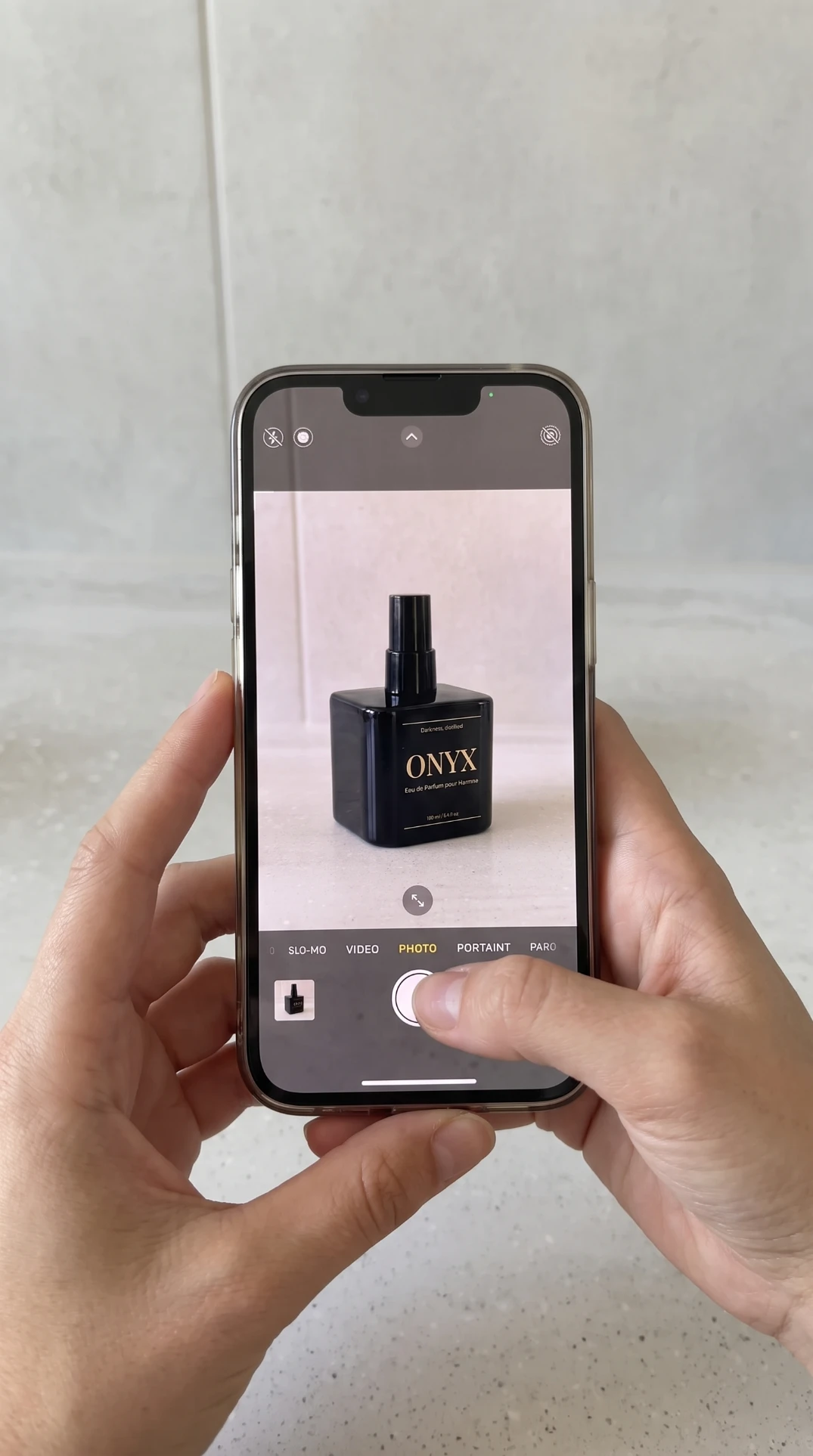 Phone photo of a black ONYX fragrance bottle on a kitchen worktop, shot handheld with no lighting or styling